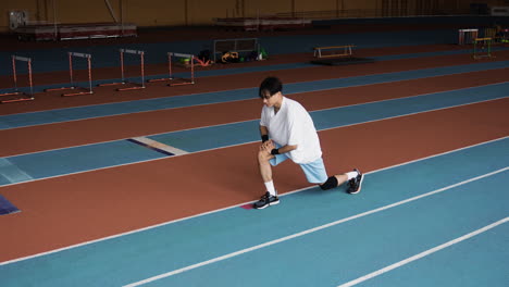 young man stretching indoors