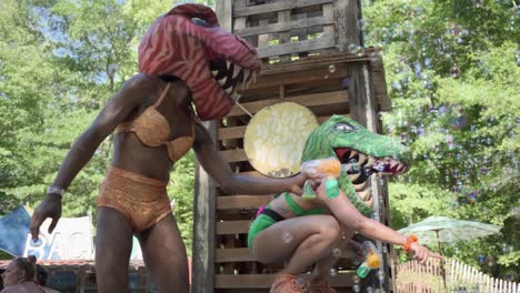 performers with dinosaur head performing and blowing baubles