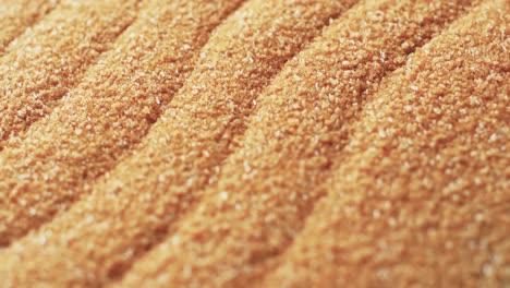 Video-of-close-up-of-sand-grains-with-pattern-and-copy-space-background