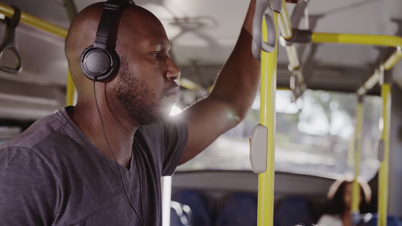 Man with headphones standing on a public bus