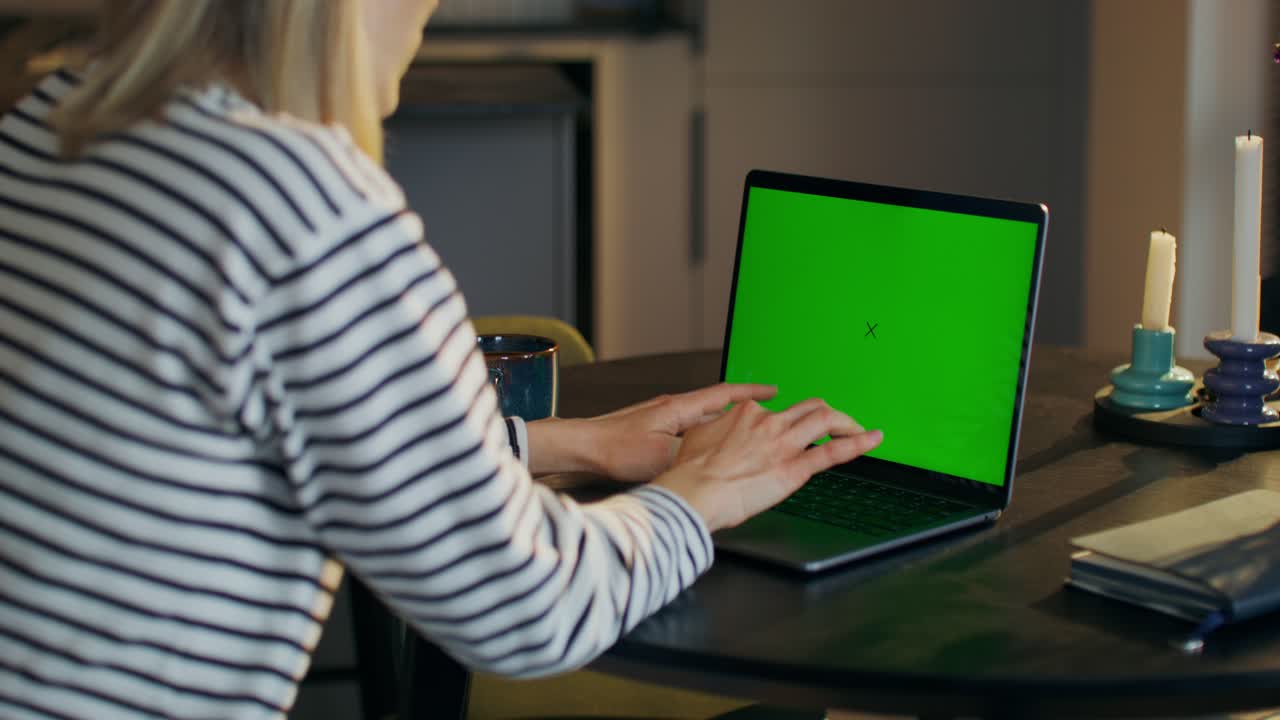 mujer trabajando en una computadora portátil con una pantalla verde