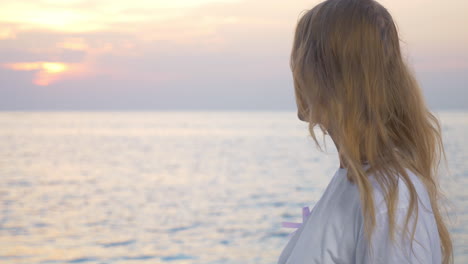 woman with pink awareness ribbon by the sea