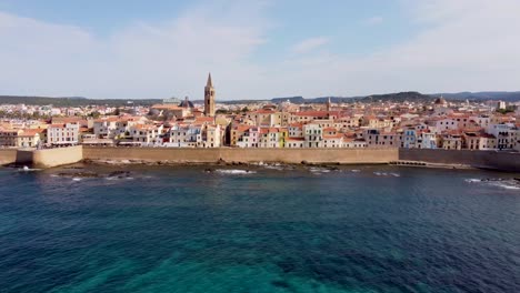 Breathtaking-clip-of-the-ocean-and-the-medieval-castle-walls-of-the-Alghero-city-in-Sardinia,-Italy