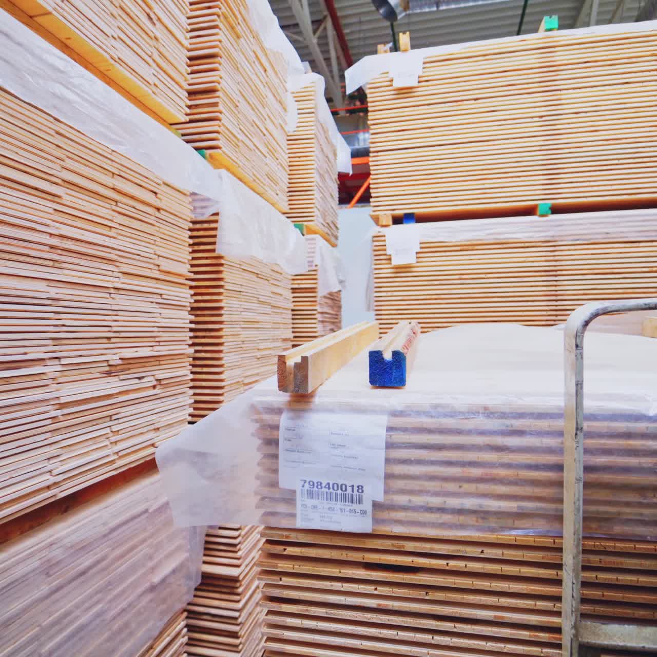 Wooden production. Forklift carries a wooden boards through the warehouse. Bunch of wooden panels moving on a truck inside the workshop.