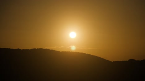 Toma-En-Cámara-Lenta-Del-Sol-Poniente-Brillando-Luz-Dorada-Sobre-La-Colina-En-Cerdeña,-Italia