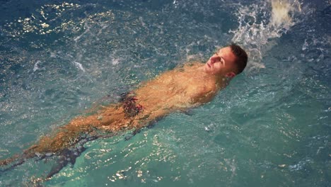 sports guy in spa swims in pool on back