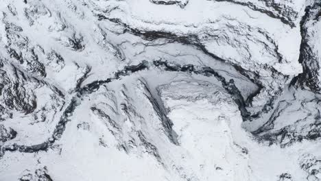 snowy canyon and mountain tops in kotargil iceland - aerials shot