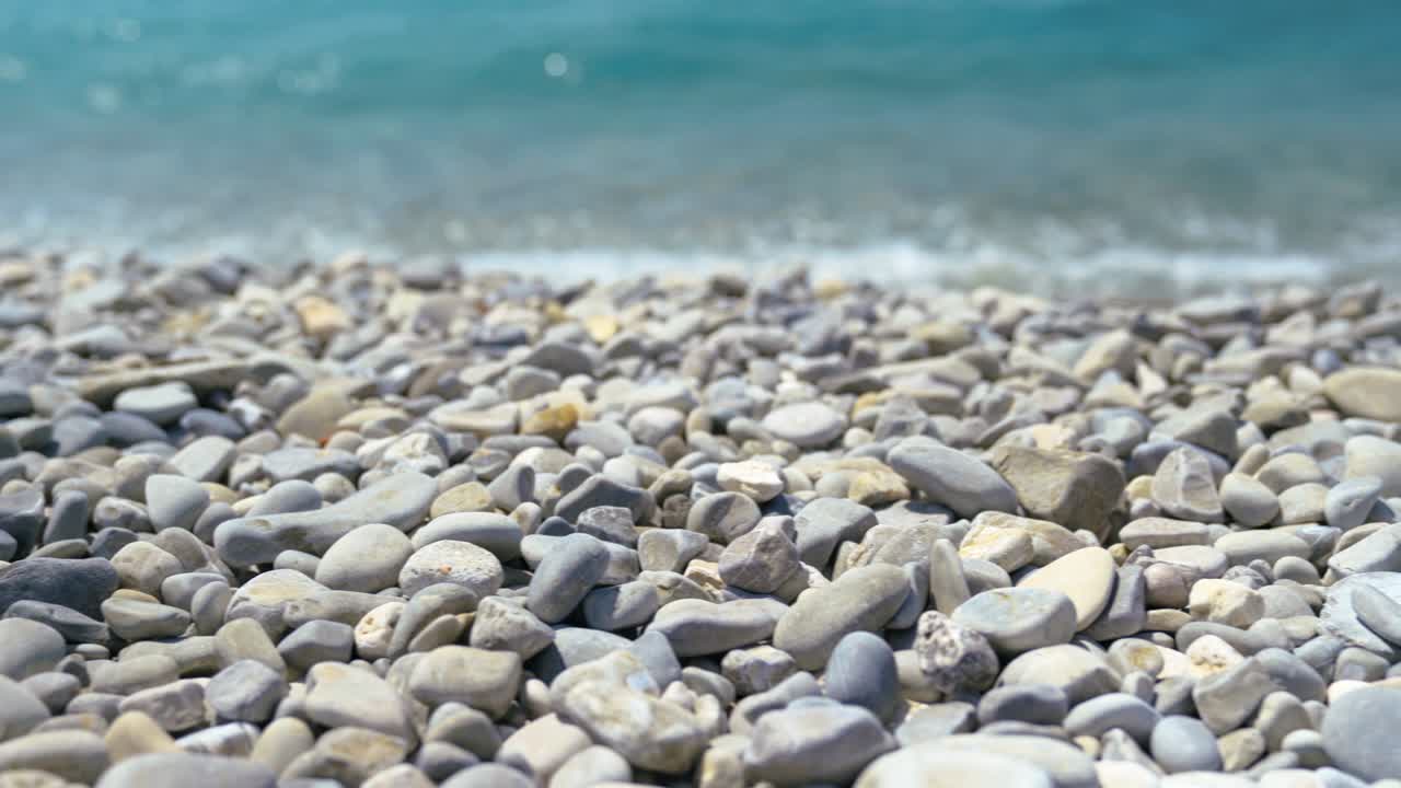 여름에 해변에서 자갈과 파도의 매크로 뷰