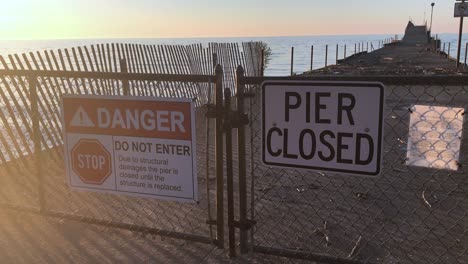 pier closed signs of danger where a beach is not safe and falling into disrepair