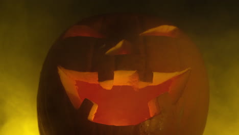 calabaza espeluznante de halloween sonriendo cara sonriente en fondo de niebla amarillo oscuro