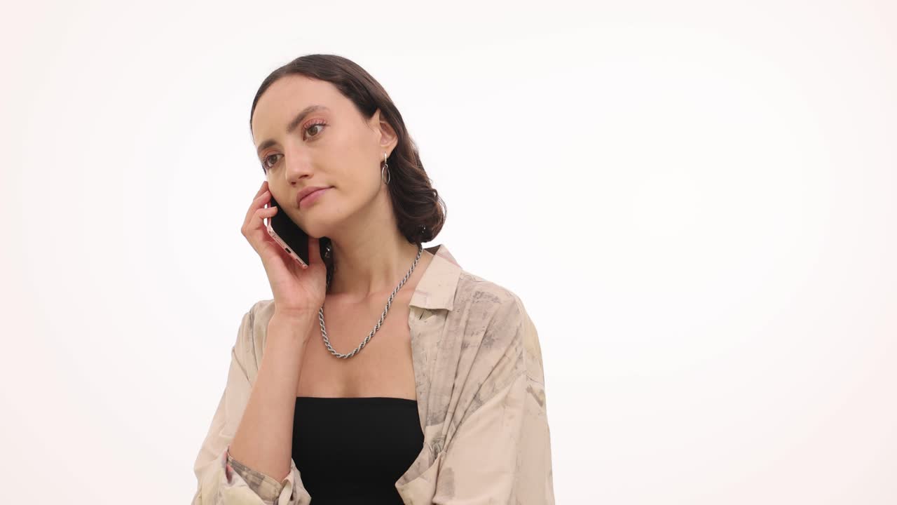 Young woman talking and looking at her smartphone