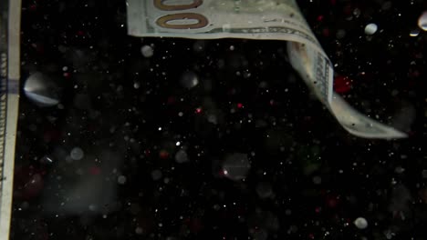 falling flying american dollar banknotes and flying mixing with the glitter sparkles on a black background in 4k loopable. high quality falling dollar banknotes in 4k. video is loopable