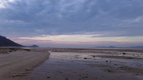 Beautiful aerial drone footage of sunrise over Koh Phangan, Thailand, featuring a pink horizon, calm sea, tropical coastline, and scenic island landscape in morning light