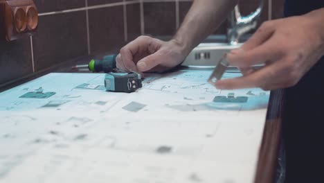 Master who produces and installs furniture studies the drawing to understand where to put the part Close-up