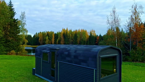 sauna cabin on lake shore with vibrant foliage in early spring