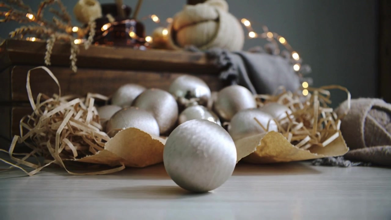 Silver Christmas Ornaments Arranged on a Table with Fairy Lights