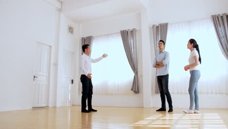real estate agent shows house to young couple