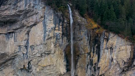 amazing waterfall over the mountain rocks falling down on a bright day in lauterbrunnen, switzerland