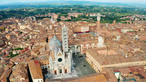 Toma-Aérea-De-Derecha-A-Izquierda-De-La-Torre-Del-Mangia-Y-Los-Tejados-De-Siena,-Toscana,-Italia