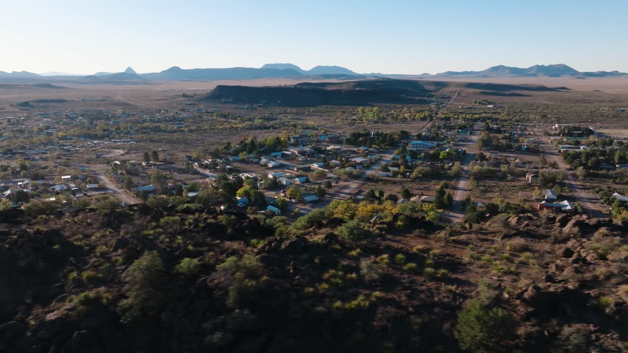 orbita aérea con vistas a la ciudad rural de texas al amanecer desde la cima de la montaña, fort davis, en el oeste de texas, cerca del parque nacional big bend en 4k.