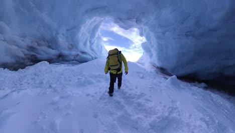 man walks through a glacier cave in slow motion