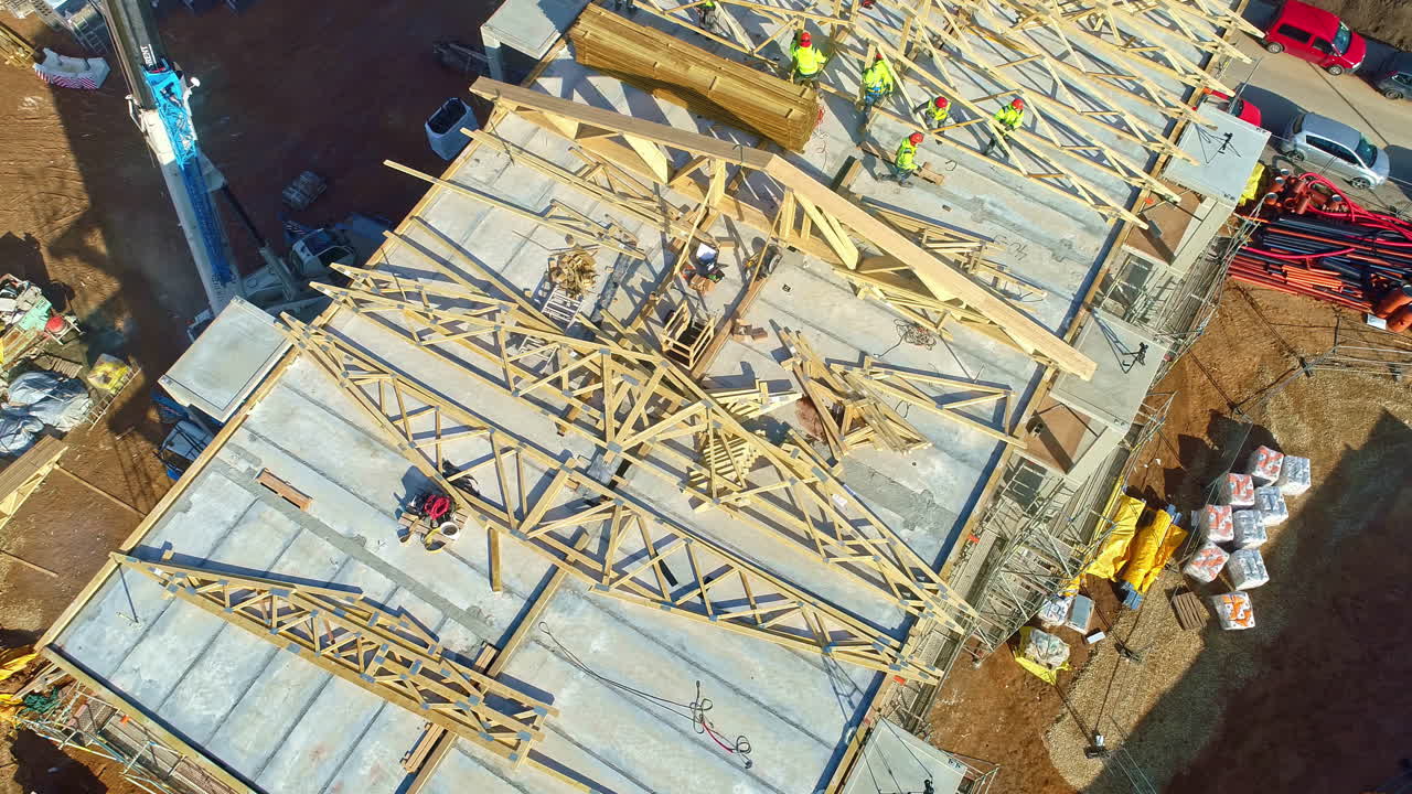Builders constructing rooftop, aerial drone view