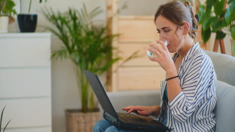 Frau-Schreibt-E-Mails,-Während-Sie-Wasser-Trinkt