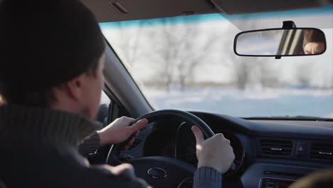 hombre conduciendo un coche en invierno