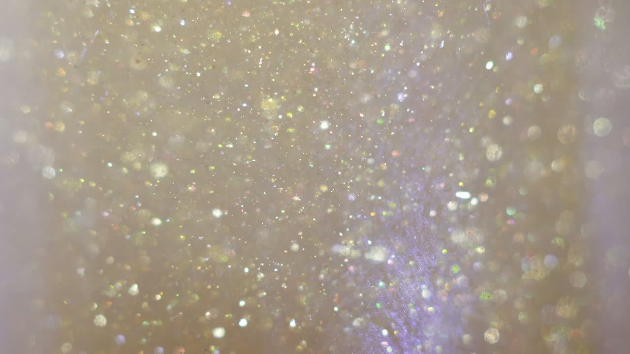 крупный план блеска, плавающего в водке. красочная золотая краска, смешивающаяся в воде. чернила, вращающиеся под водой. облако шелковистой чернил. макровидение