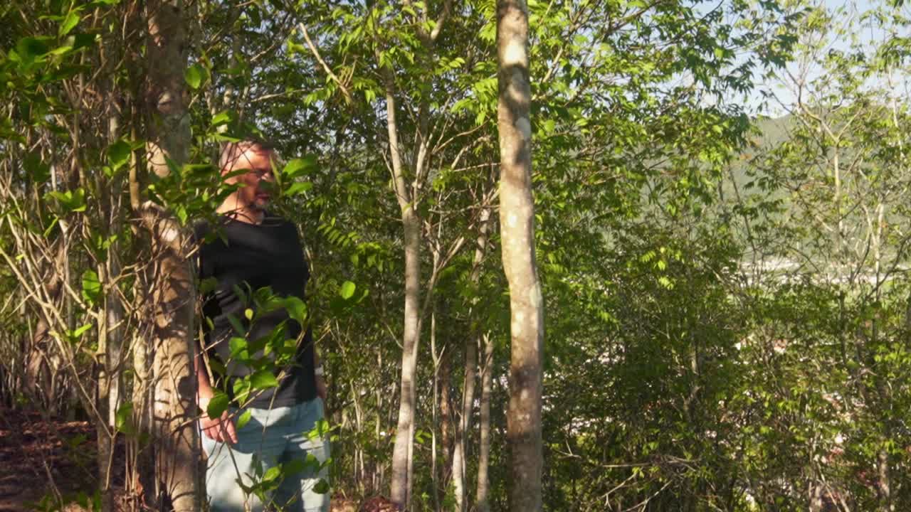 man walking down hill on a nature walk.