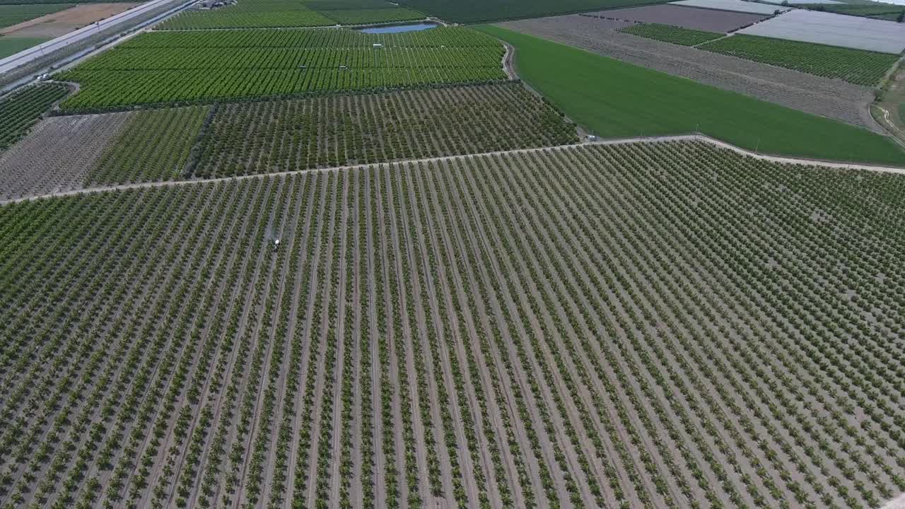 Unmanned aerial vehicle footage of the tractor spraying the garden
