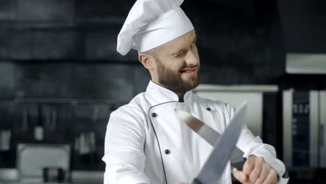 Happy-chef-having-fun-with-knives.-Chef-man-playing-with-kitchen-tools