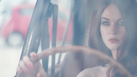 una mujer conduciendo un coche de época.