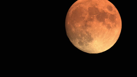 large orange full moon rising in the sky, night astro time lapse