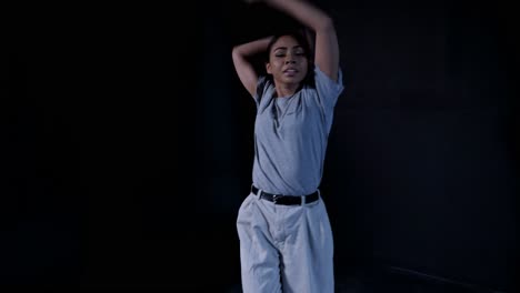 young latina in gray office clothes dancing whacking contemporary with eye contact