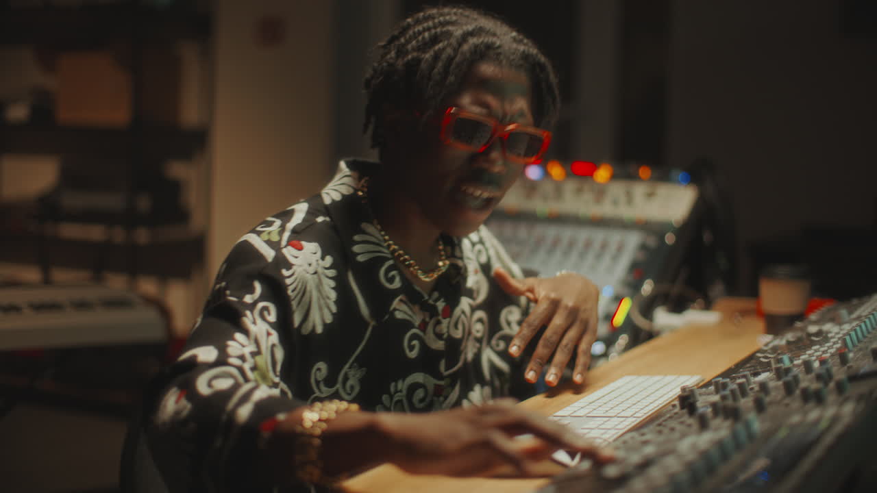 African American Music Producer Mixing Sound in Recording Studio