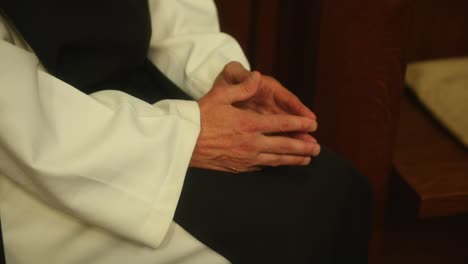 Beautiful-scene-of-the-hands-of-a-monk-praying-in-a-church-close-up-shot