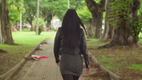 dressed in a jacket and boots, a woman enjoys a day out at a lush caribbean park