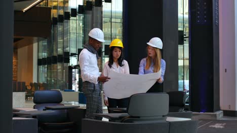 group of architects discussing over blueprint in office 4k