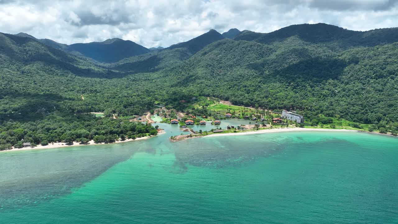 Luxury resort “Ghost Ship” chalets along the coastline of Koh Chang Island, Trat, Thailand, showing turquoise waters, forested hills and high-end villa escapes, aerial view
