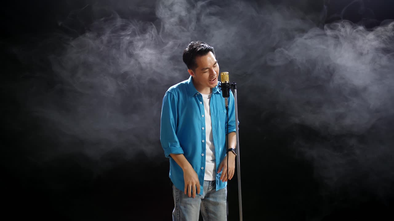 무대에서 마이크에 노래하는 남자