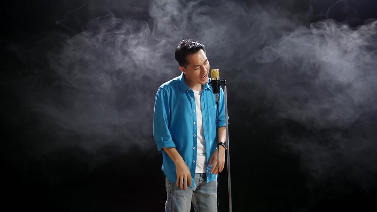 Man Singing into Microphone on Stage