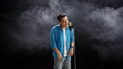 man singing into microphone on stage