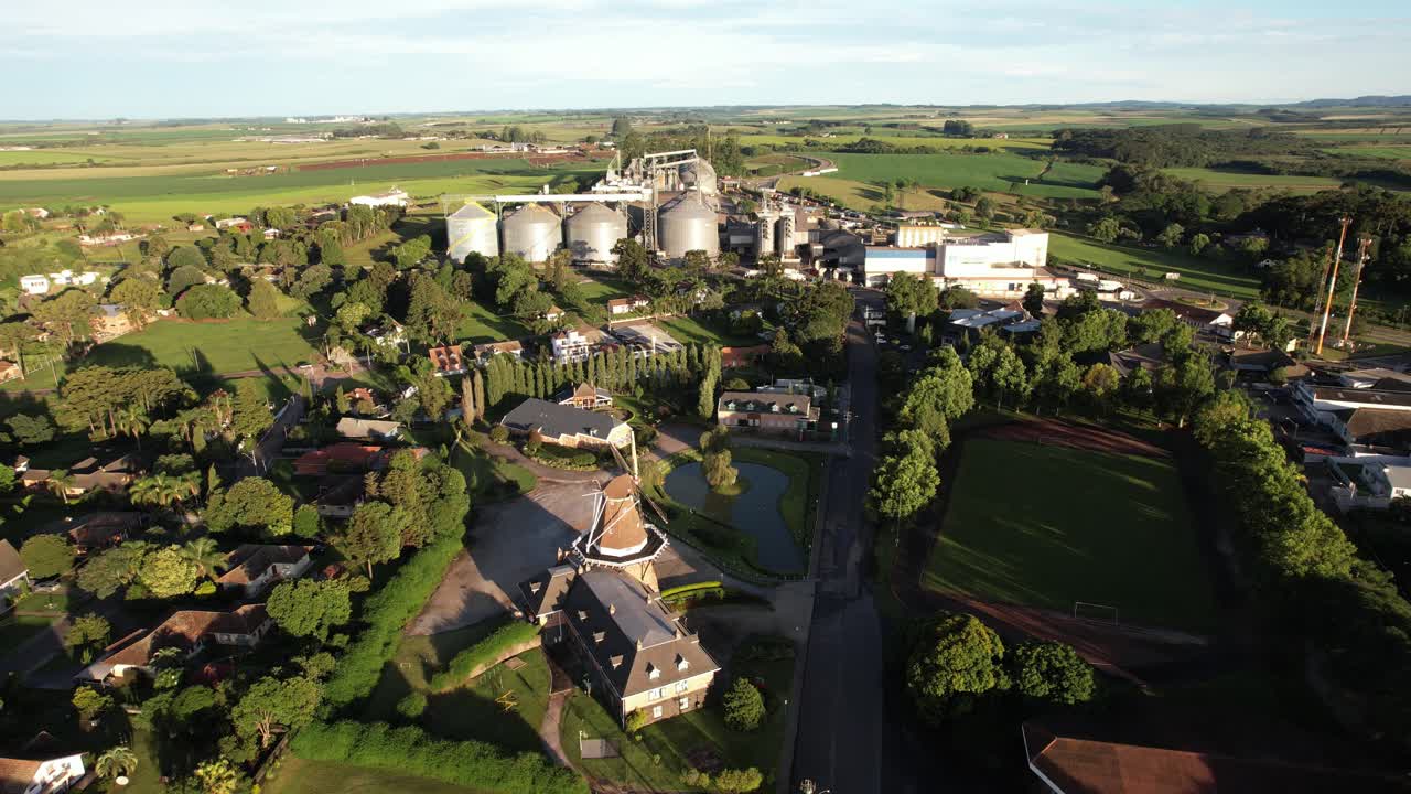 orbital movement with drone in beautiful landscape with dutch windmill and factories in the background, soft light and evening temperature