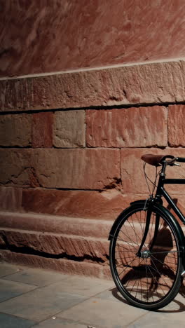 vintage bicycle leaning against stone wall at night