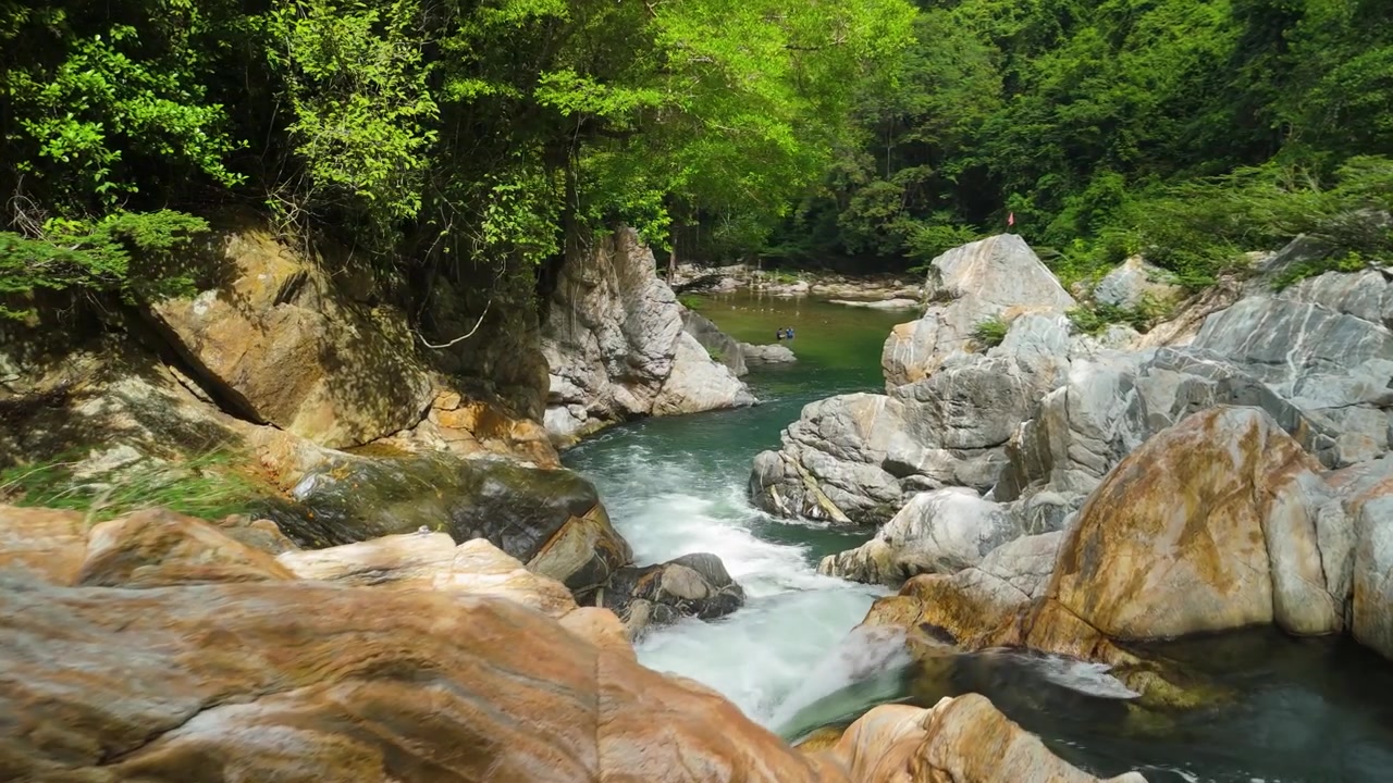 Tampilan udara jeram deras yang mengalir melalui ngarai batu marmer ke kolam zamrud Poza Encantada yang dikelilingi hutan lebat dekat Santa Marta Kolombia