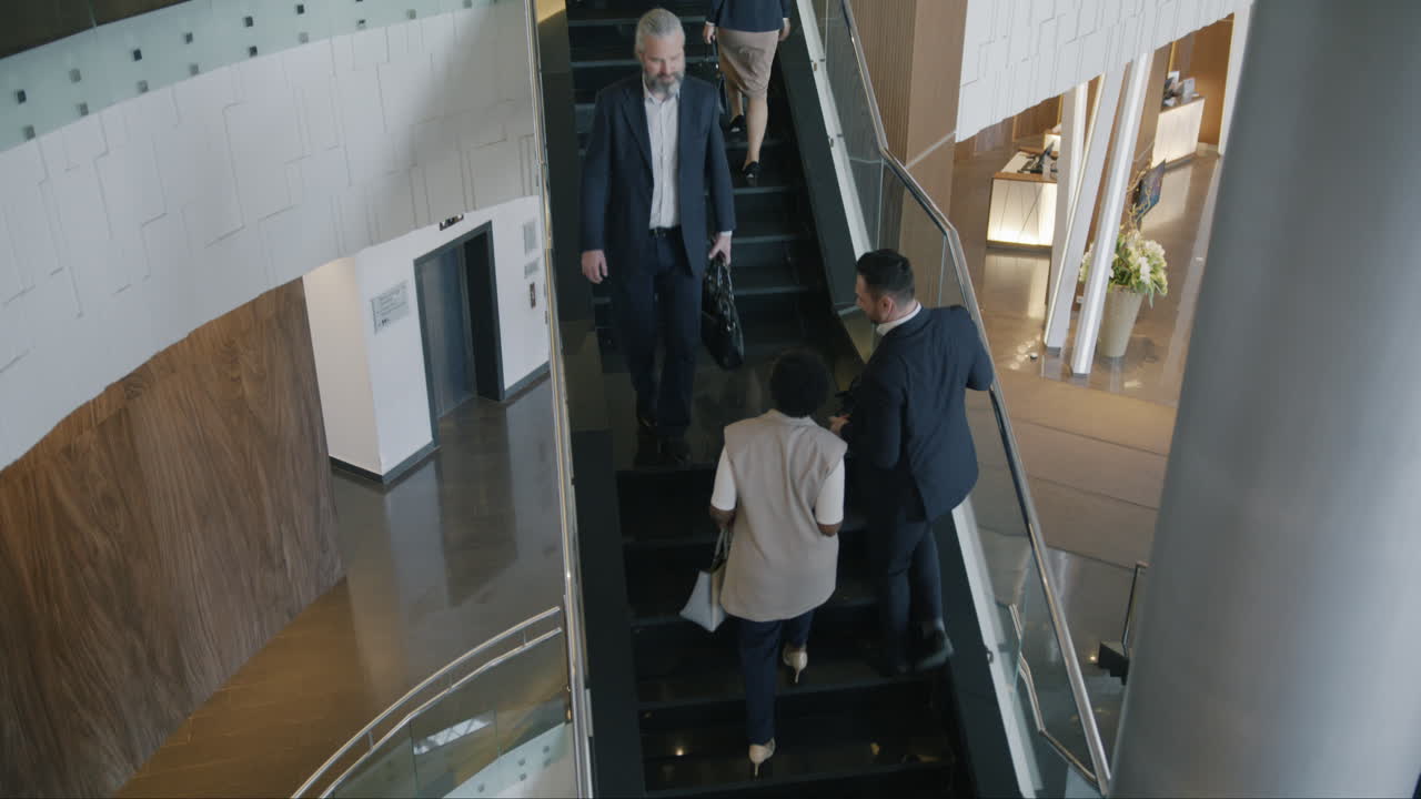 Business People Walking Upstairs in Modern Office Building