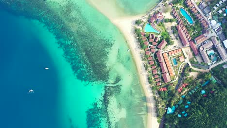 thailand, aerial - colorful roofs of the luxury resorts with saltwater swimming pools on the coast of tropical island