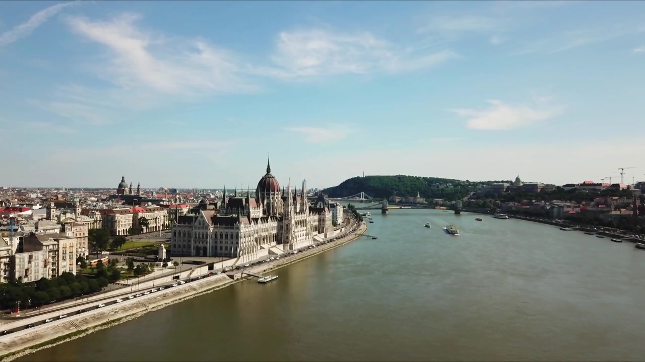 Veduta aerea di Budapest con l'iconico Parlamento ungherese lungo il fiume Danubio, circondato da architettura storica, un vivace paesaggio urbano e punti di riferimento come il Castello di Buda e il Ponte delle Catene.