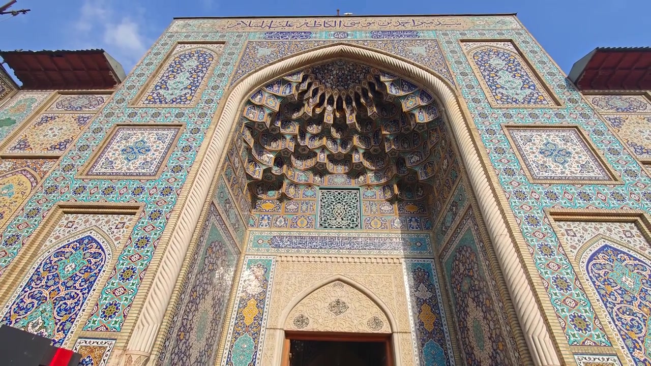 Entrada de uma mesquita persa tradicional com azulejos intrincados.
